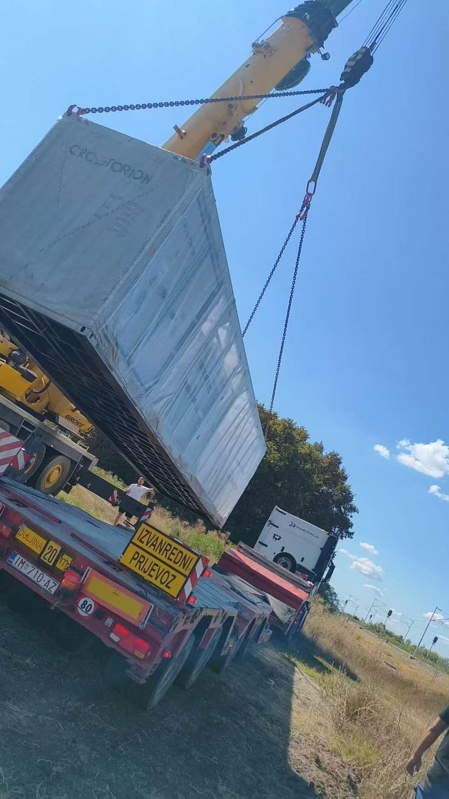 Un contenedor izado de la góndola, con el cartel de transporte especial todavía en el remolque
