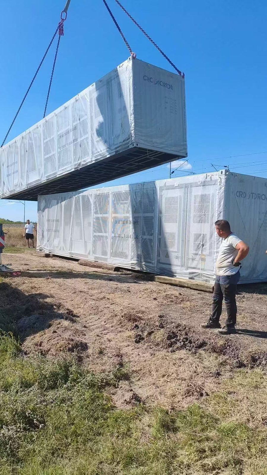 Un contenedor bajando a su sitio junto a otro ya colocado