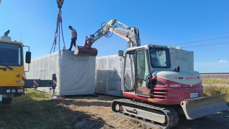 Kran und Bagger arbeiten neben CROSTORION-Containern in Vođinci